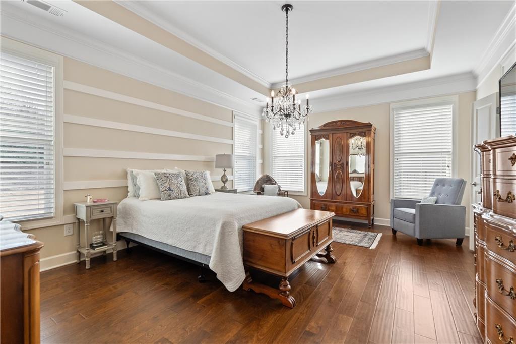 3457 Locust Cove Road Gainesville, GA 30504 - Photo 26 of 54 a spacious bedroom with a bed and a chandelier