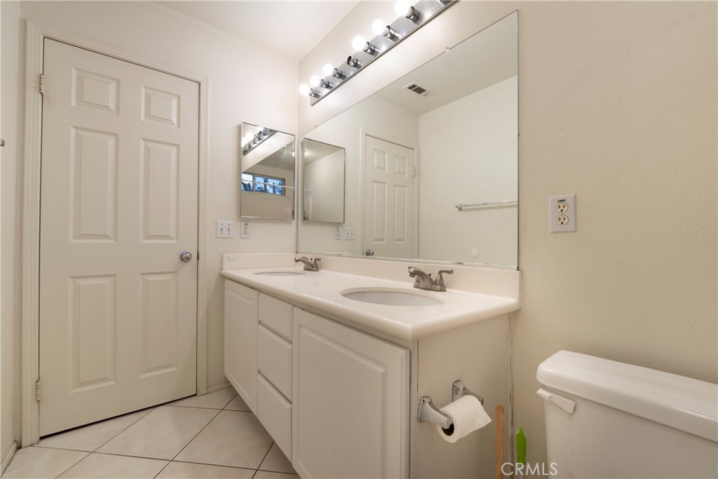 6319 Lavender Street Eastvale, CA 92880 - Photo 35 of 39 a bathroom with a sink a toilet and a mirror