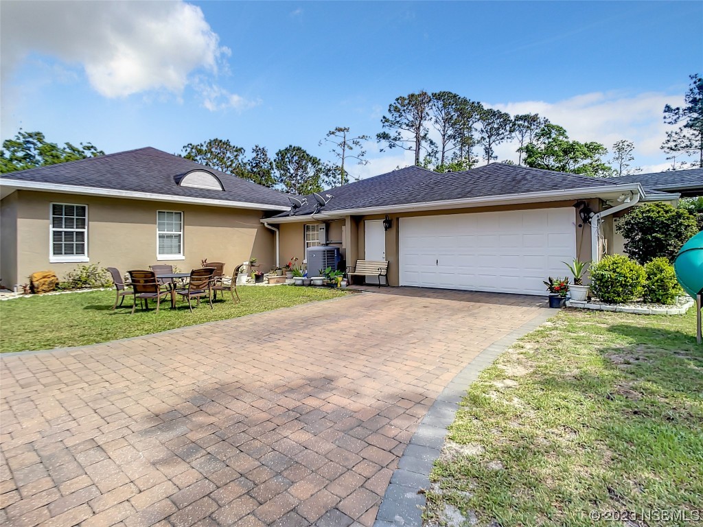 32 Winchester Road Ormond Beach, FL 32174 - Photo 55 of 84 a front view of a house with a garden and outdoor seating