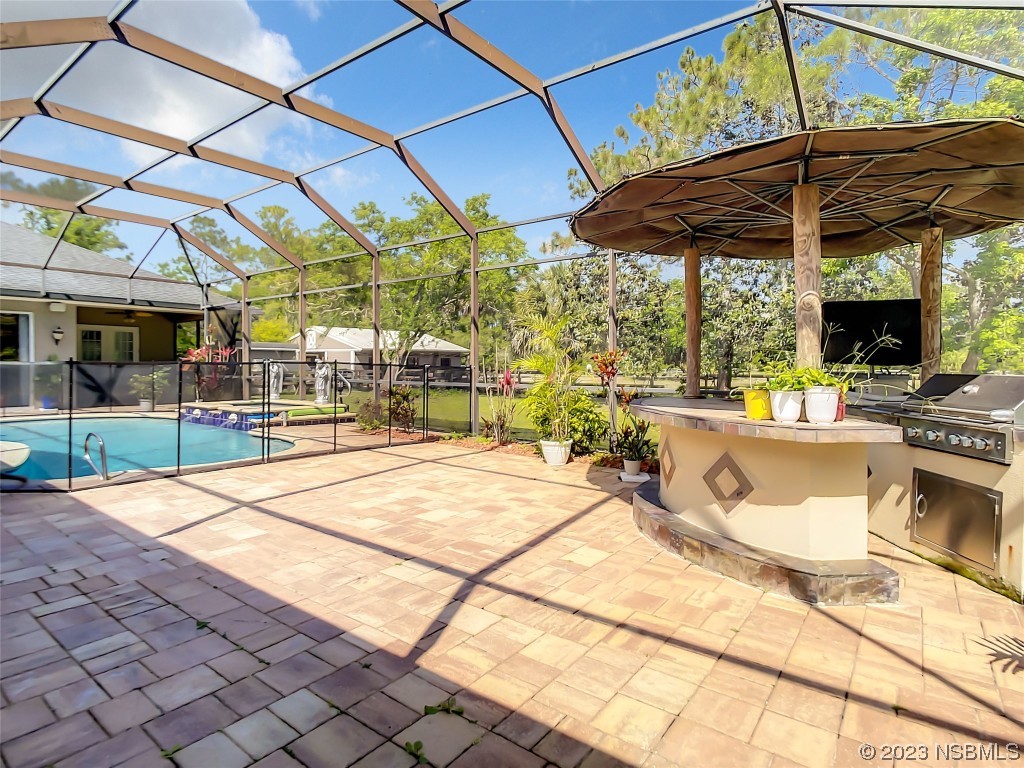 32 Winchester Road Ormond Beach, FL 32174 - Photo 79 of 84 a view of a patio with a table and chairs under an umbrella