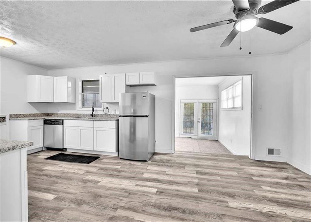 2356 County Line Road Southwest Atlanta, GA 30331 - Photo 4 of 8 a kitchen with stainless steel appliances kitchen island granite countertop a refrigerator a sink a stove and white cabinets