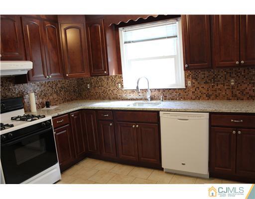 10 Butler Road Edison, NJ 08820 - Photo 8 of 13 a kitchen with granite countertop stainless steel appliances a stove a sink and a microwave