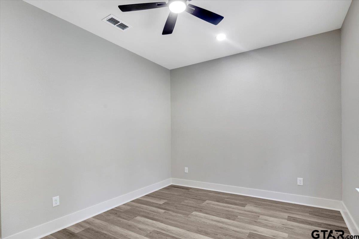 147 Arvel Street Bullard, TX 75757 - Photo 14 of 23 an empty room with a ceiling fan and wooden floor