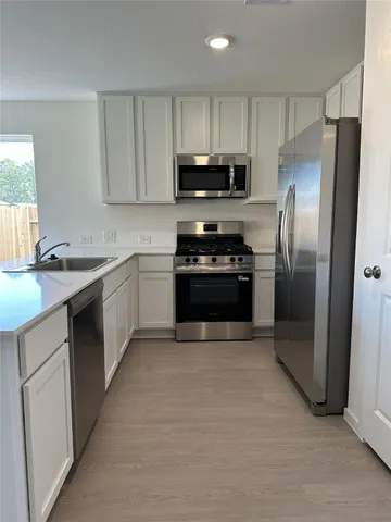 a kitchen with stainless steel appliances granite countertop a stove a refrigerator and a sink