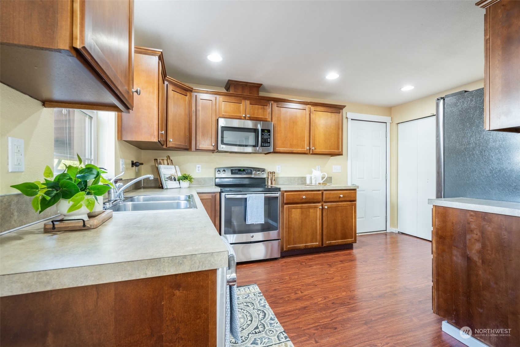 20122 Shamon Court Southwest Centralia, WA 98531 - Photo 19 of 40 a kitchen with stainless steel appliances granite countertop a stove a sink a microwave a refrigerator white cabinets and wooden floor