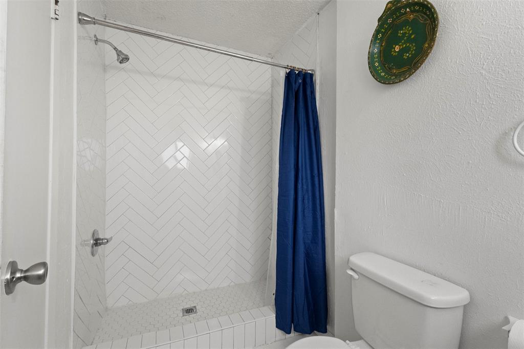 3304 Crest Ridge Drive Dallas, TX 75228 - Photo 16 of 16 a bathroom with a shower a toilet and a shower