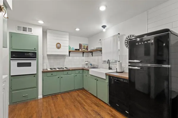 a kitchen with stainless steel appliances granite countertop a refrigerator and a sink