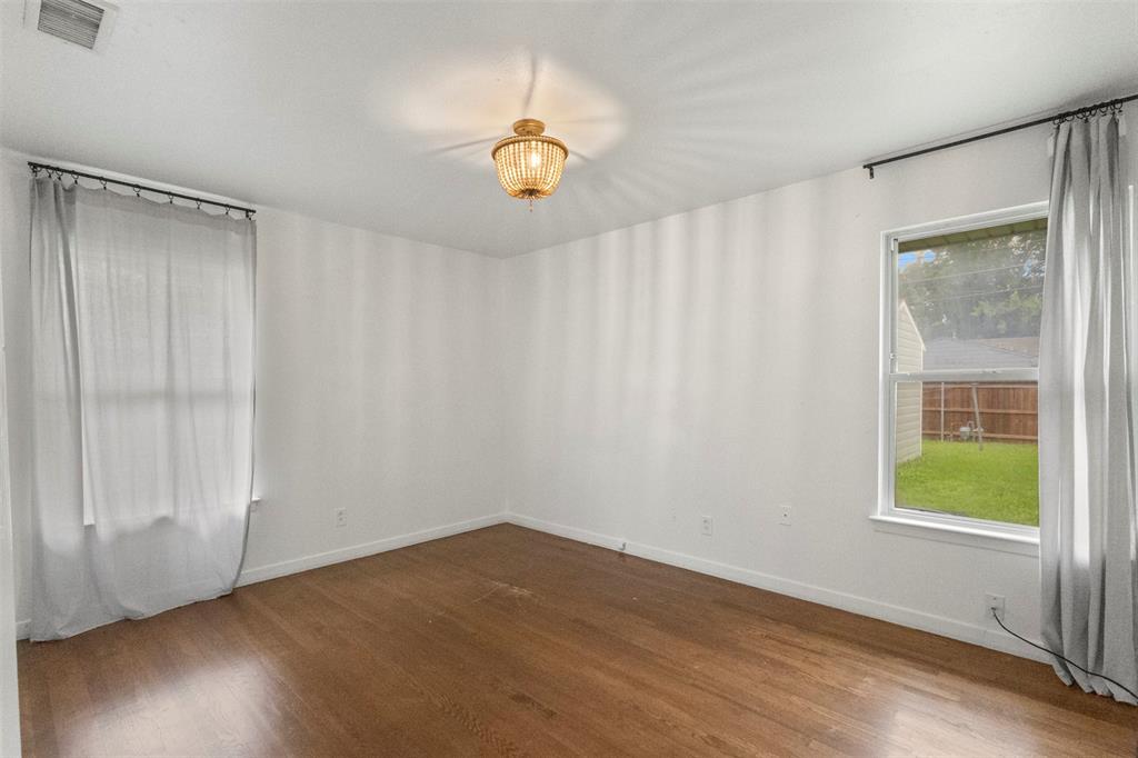 3304 Crest Ridge Drive Dallas, TX 75228 - Photo 7 of 16 an empty room with wooden floor and windows