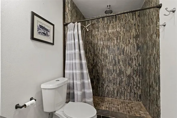 a white toilet sitting next to a shower curtain