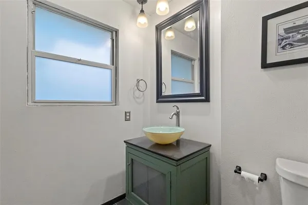 a bathroom with a toilet a sink and mirror