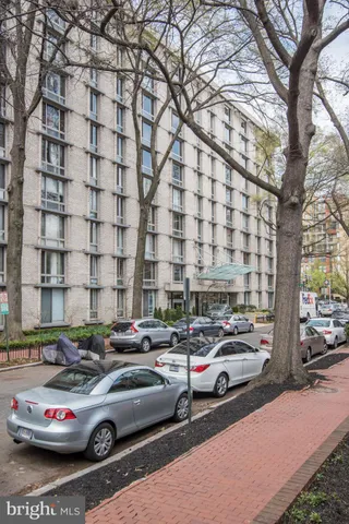 a car parked in front of a cars parked on a sidewalk