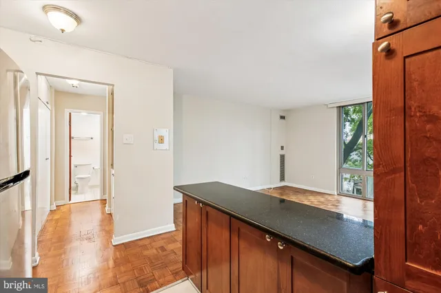 a kitchen with stainless steel appliances granite countertop a refrigerator a stove and a sink with wooden floor