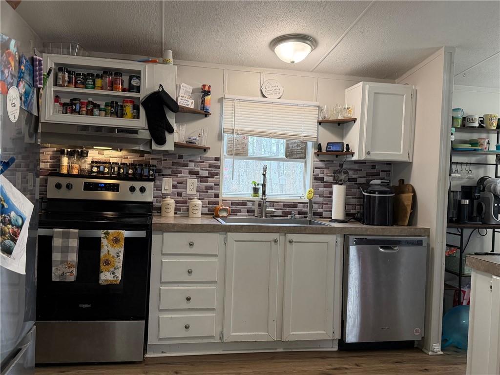 828 Harrison Road Carrollton, GA 30117 - Photo 6 of 20 a kitchen with stainless steel appliances granite countertop a stove and cabinets