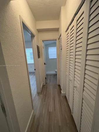 a view of a hallway with wooden floor