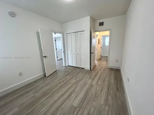 an empty room with wooden floor and a window