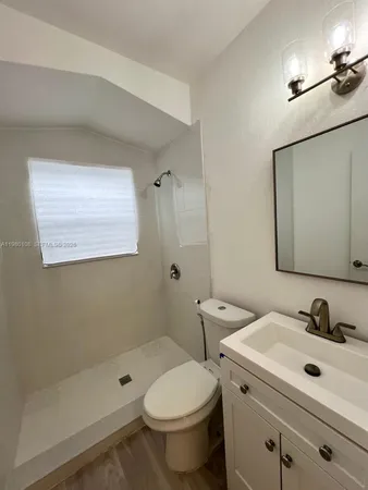 a bathroom with a sink toilet a mirror and shower