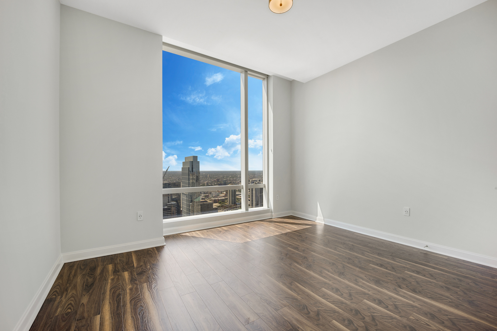 111 West Wacker Drive, Unit PH01 Chicago, IL 60601 - Photo 12 of 37 an empty room with wooden floor and windows