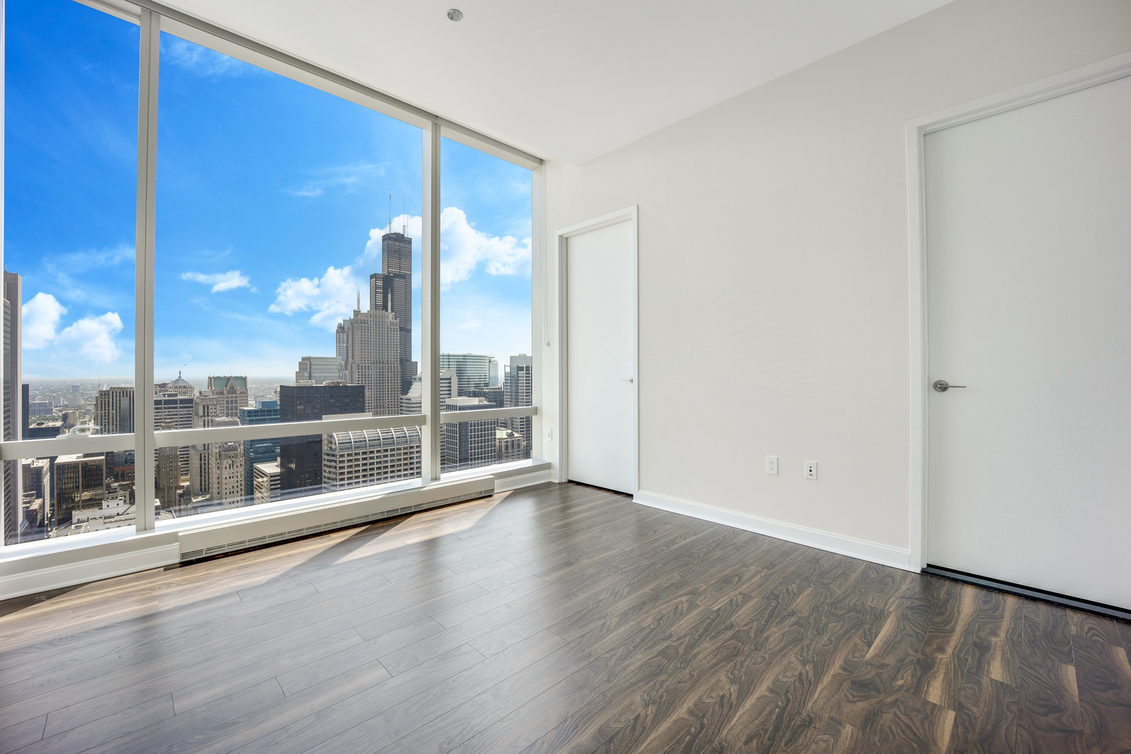 111 West Wacker Drive, Unit PH01 Chicago, IL 60601 - Photo 13 of 37 an empty room with wooden floor and windows