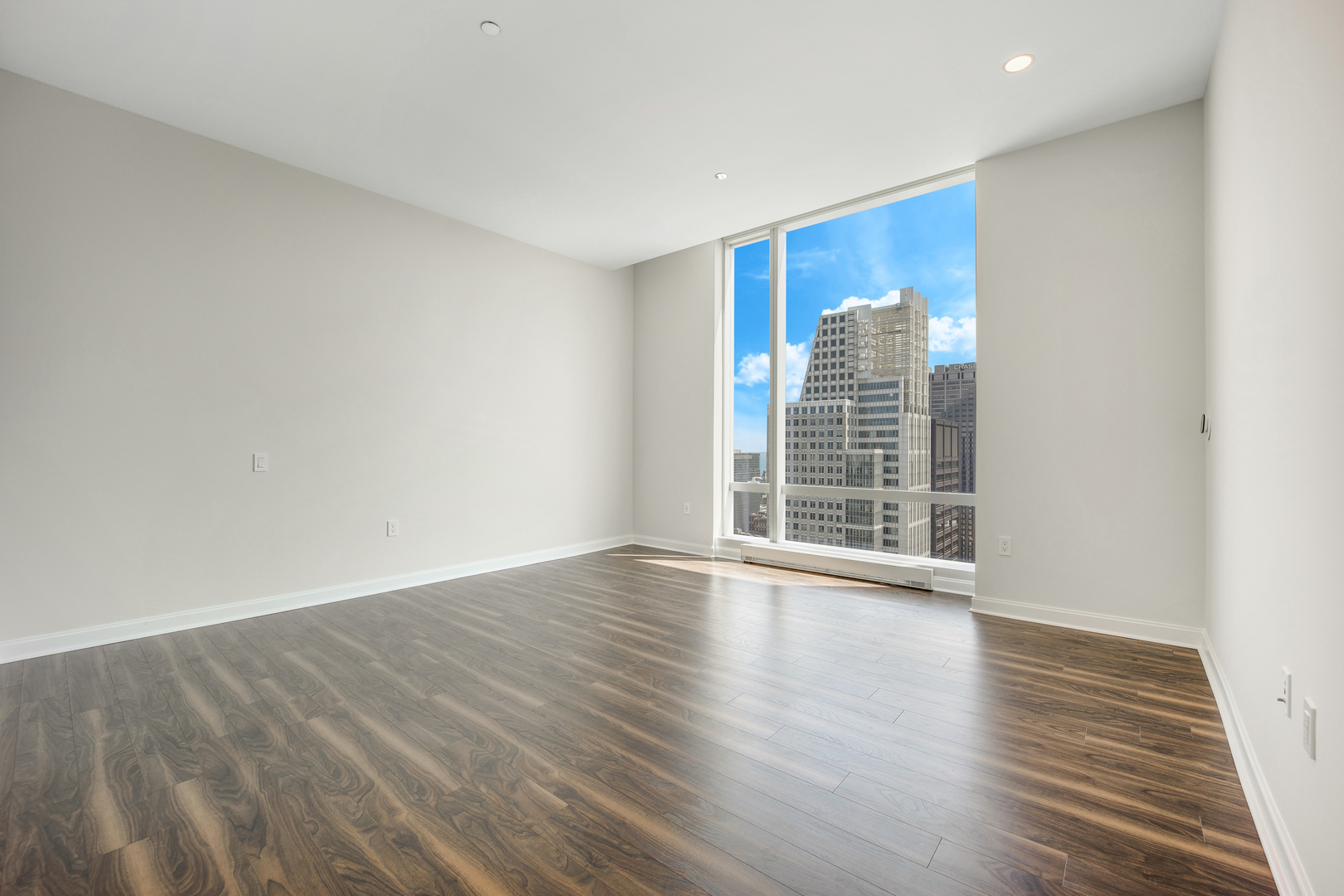 111 West Wacker Drive, Unit PH01 Chicago, IL 60601 - Photo 17 of 37 a view of an empty room with wooden floor and a window