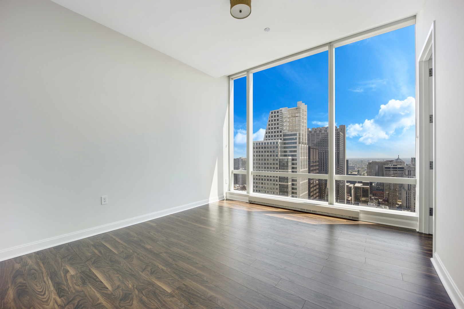 111 West Wacker Drive, Unit PH01 Chicago, IL 60601 - Photo 20 of 37 a view of an empty room with wooden floor and a window