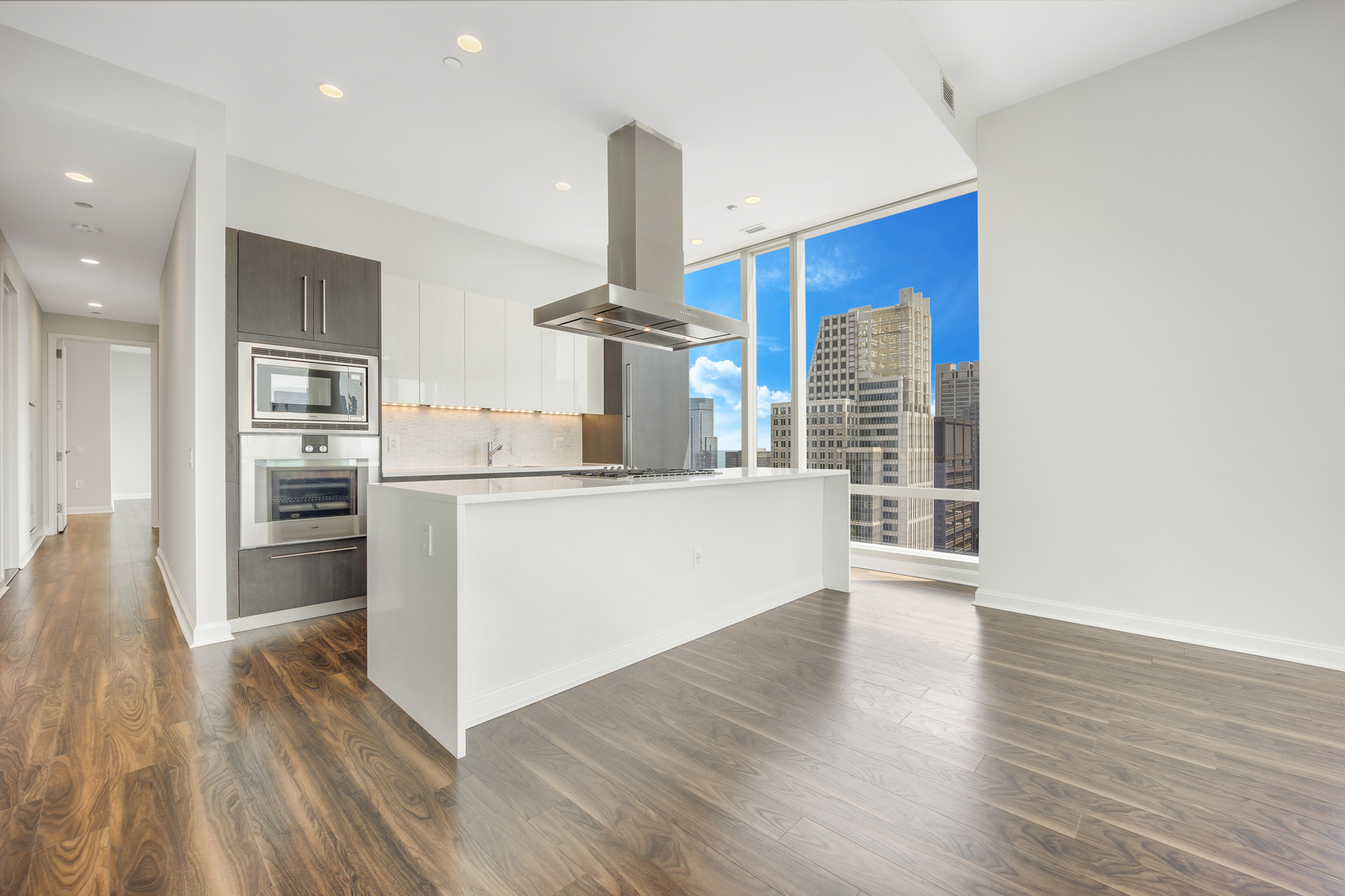 111 West Wacker Drive, Unit PH01 Chicago, IL 60601 - Photo 5 of 37 a large kitchen with stainless steel appliances a large counter top a stove and a wooden floors