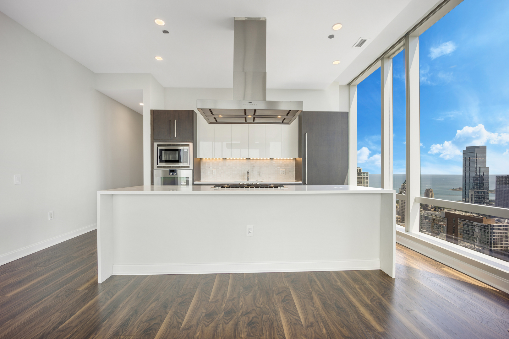 111 West Wacker Drive, Unit PH01 Chicago, IL 60601 - Photo 6 of 37 a large white kitchen with wooden floor