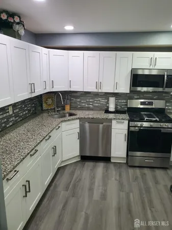 a kitchen with stainless steel appliances granite countertop a sink a stove and cabinets