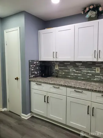 a view of kitchen with granite countertop cabinets