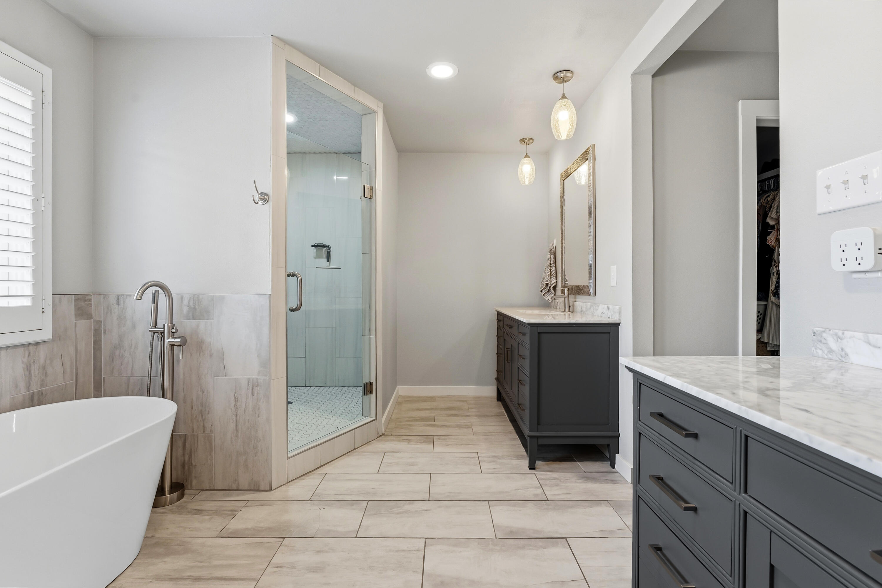 4628 94th Street Lubbock, TX 79424 - Photo 27 of 41 a bathroom with a granite countertop sink a mirror and a bathtub