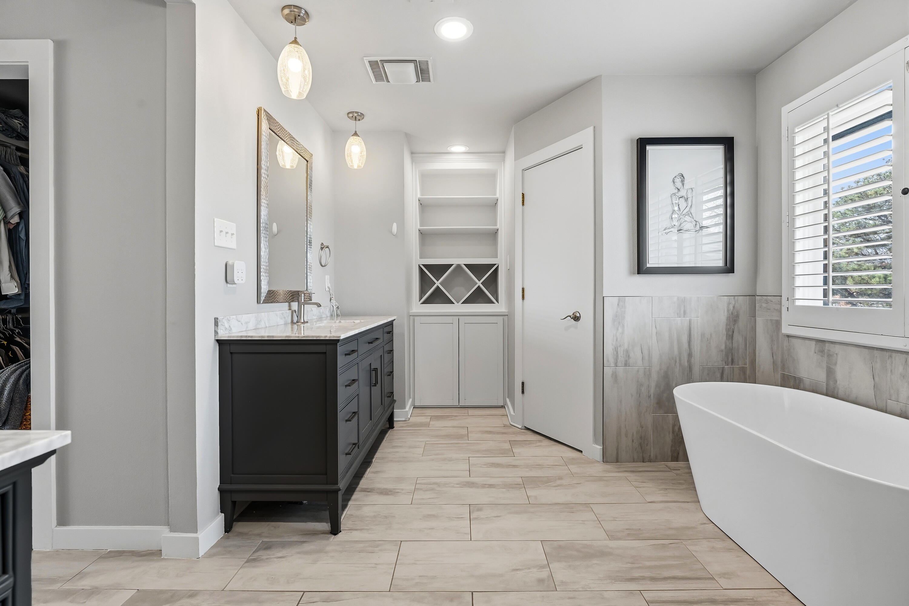 4628 94th Street Lubbock, TX 79424 - Photo 28 of 41 a spacious bathroom with a double vanity sink a mirror and a bathtub
