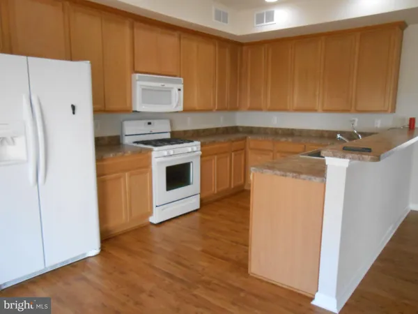 a kitchen with a refrigerator sink and cabinets