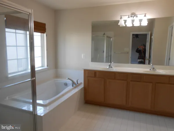 a bathroom with a tub a sink and mirror