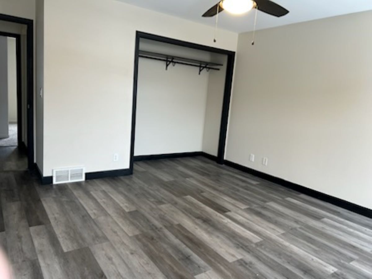 711 Prospect Street Kirkland, IL 60146 - Photo 12 of 23 a view of an empty room with wooden floor and a ceiling fan