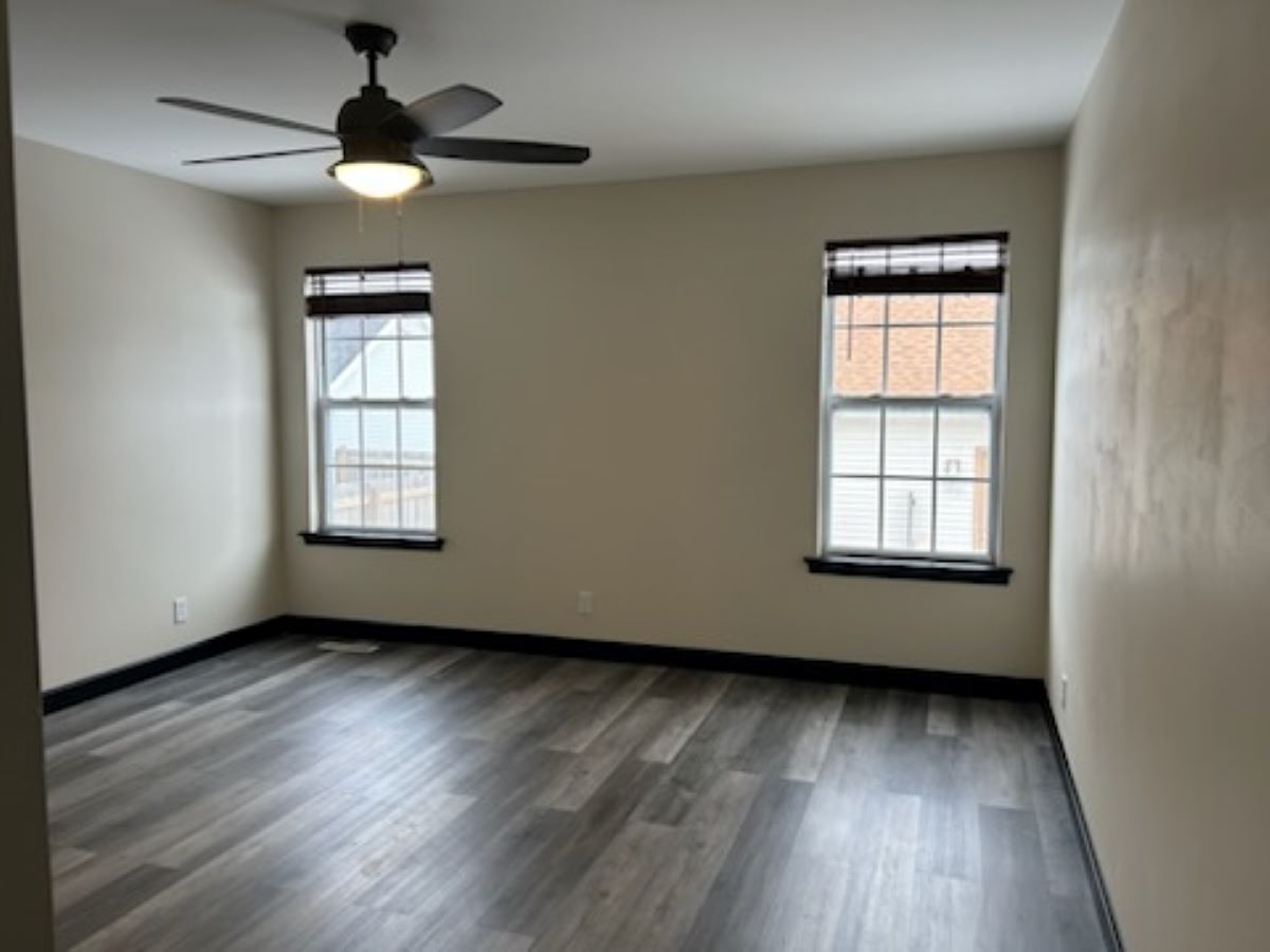 711 Prospect Street Kirkland, IL 60146 - Photo 13 of 23 an empty room with wooden floor chandelier fan and windows
