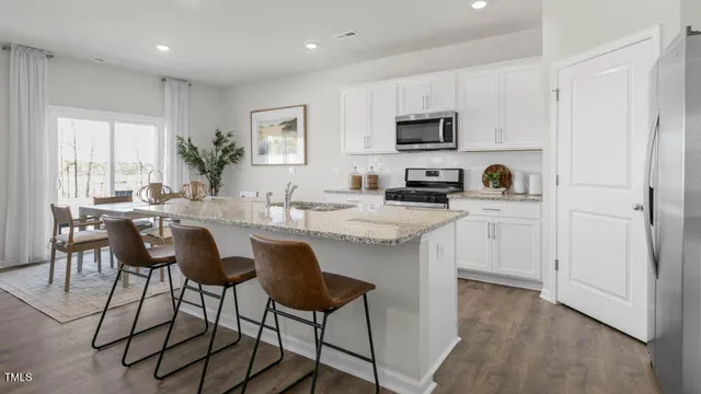 a kitchen with stainless steel appliances kitchen island granite countertop a sink and cabinets