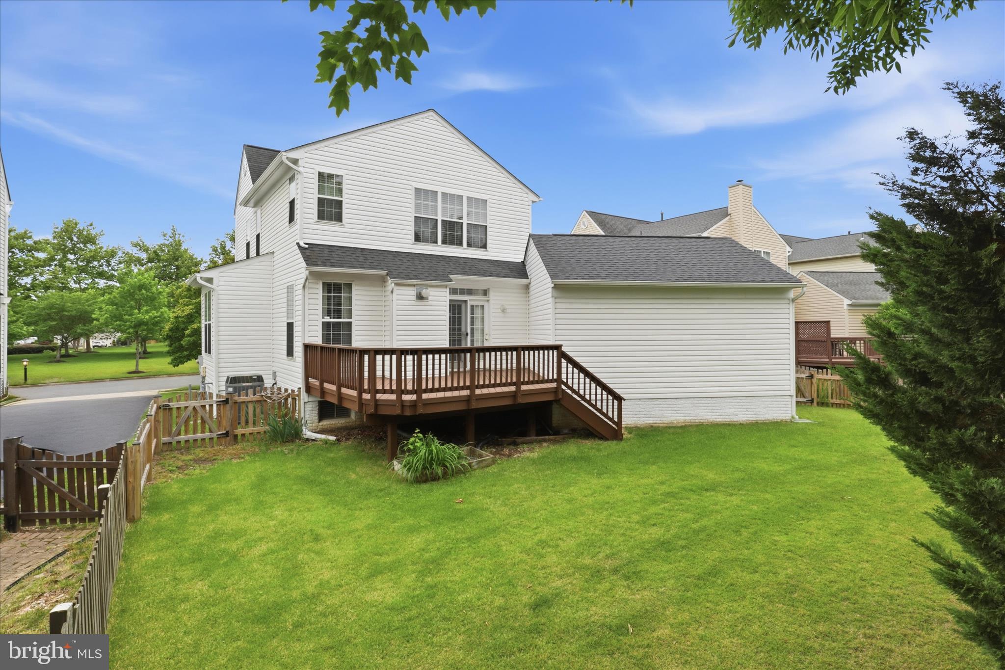 25352 Ripleys Field Drive Chantilly, VA 20152 - Photo 30 of 54 a white house that has a small yard and couches chairs with wooden fence