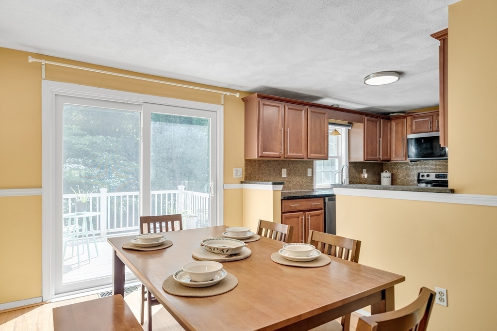 58 MacIntosh Lane, Unit 58 Boxborough, MA 01719 - Photo 5 of 23 a kitchen with a table chairs stove and dining table