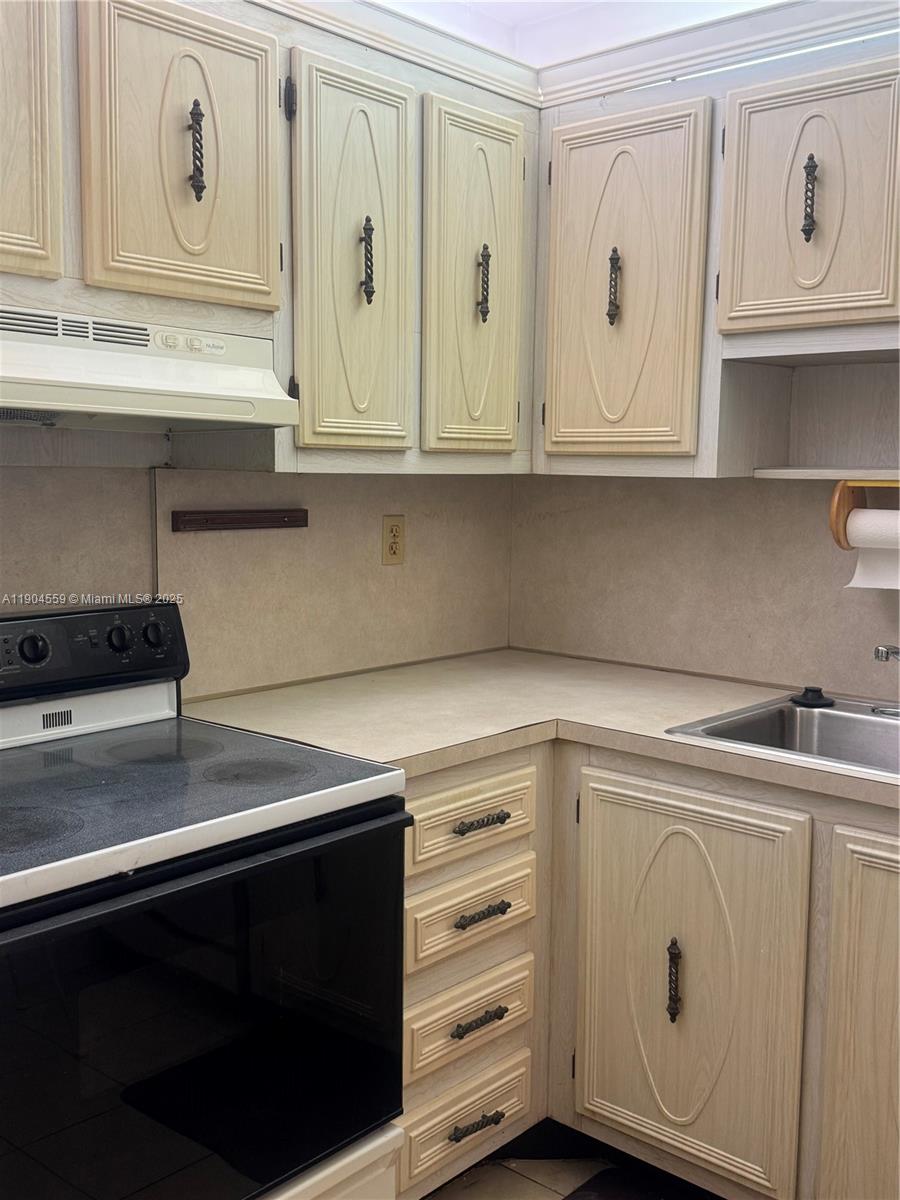 5640 Southwest 3rd Place, Unit 110 Margate, FL 33068 - Photo 21 of 28 a kitchen with white cabinets and sink