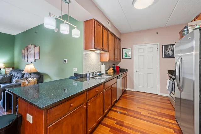 a kitchen with stainless steel appliances granite countertop a sink and refrigerator