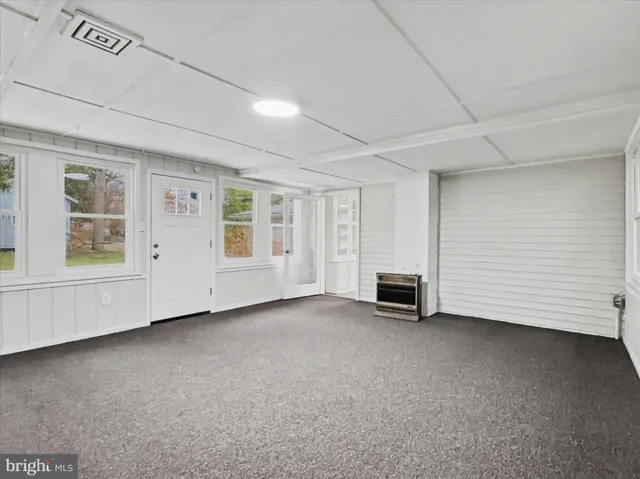 a view of an empty room with a fireplace and a window