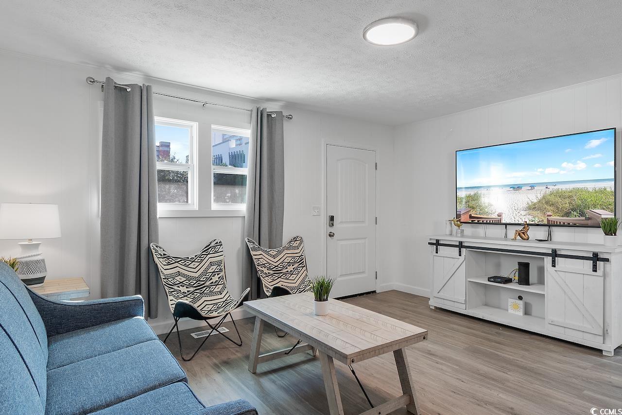 409 17th Avenue North, Unit 4 Myrtle Beach, SC 29577 - Photo 5 of 22 Living area featuring light wood-style floors and a textured ceiling