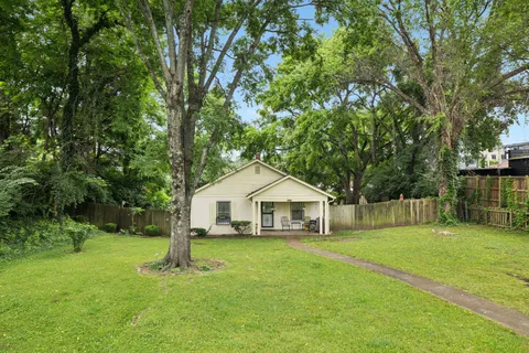 a front view of house with a garden and trees