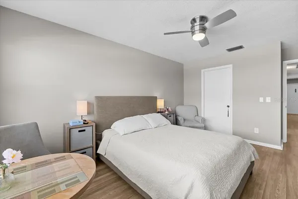 a bedroom with a bed and a flat tv screen on dresser