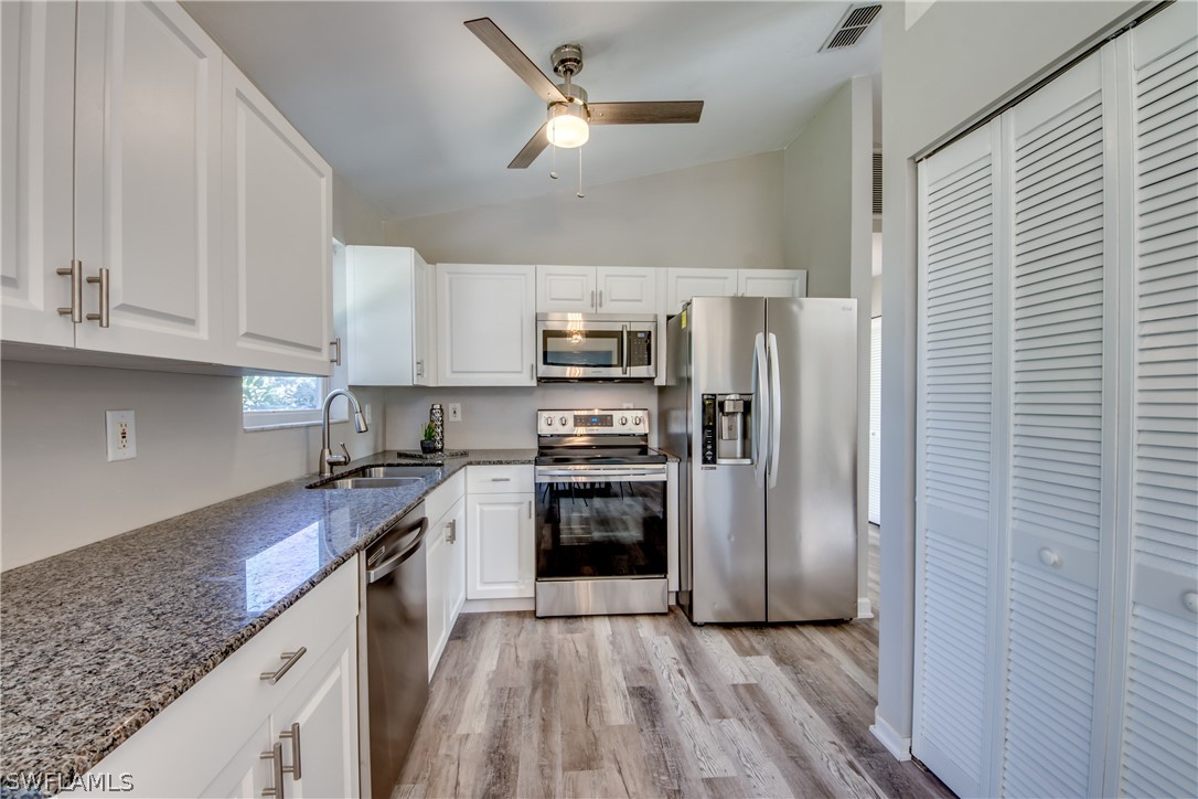 18372 Hawthorne Road Fort Myers, FL 33967 - Photo 3 of 28 a kitchen with kitchen island granite countertop a stove a refrigerator and a sink