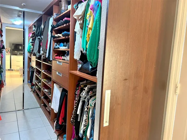 a view of walk in closet with clothes
