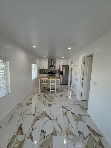 a large white kitchen with sink table and chairs