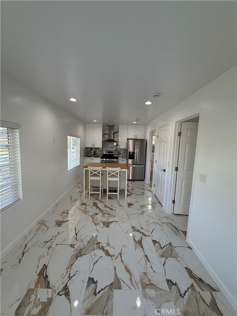 7476 Brookside Road Rancho Cucamonga, CA 91730 - Photo 7 of 13 a large white kitchen with sink table and chairs