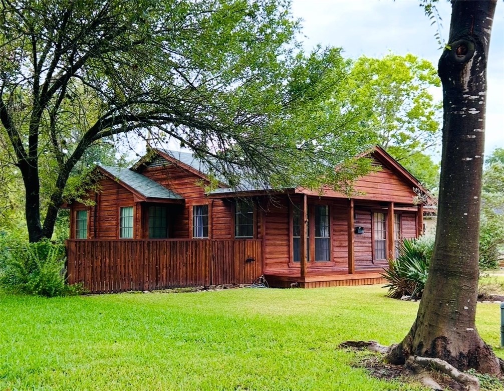 a view of backyard with wooden fence and large trees