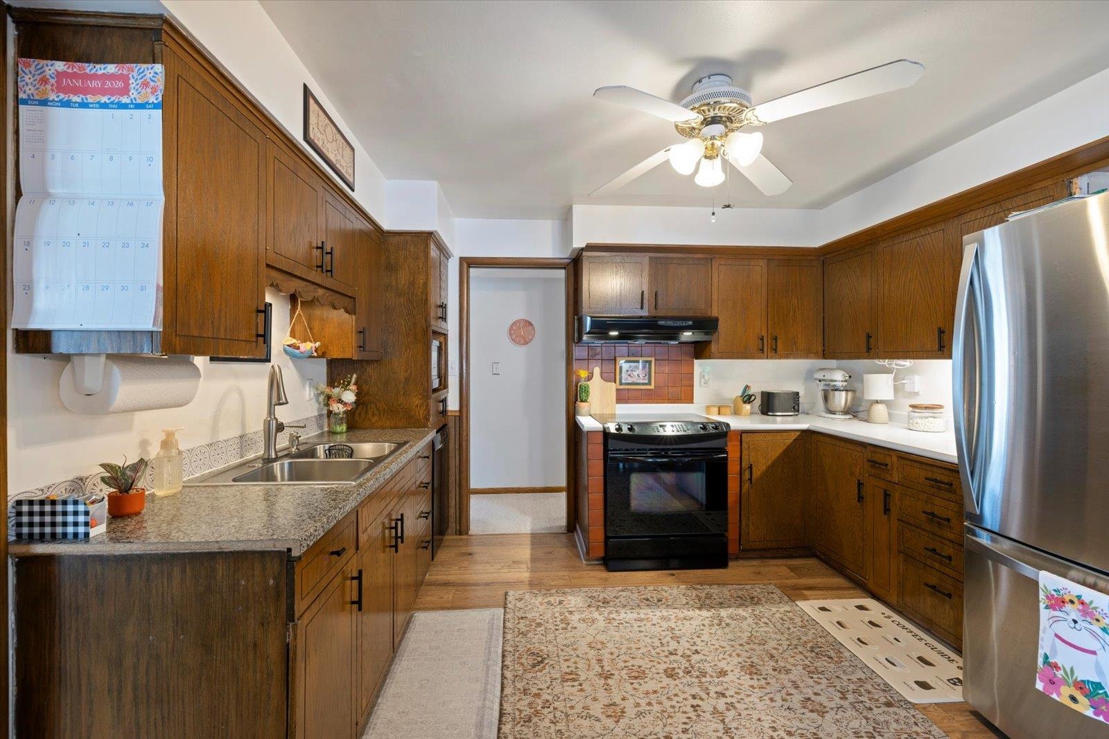 502 North Inner Drive Hibbing, MN 55746 - Photo 16 of 57 Kitchen featuring freestanding refrigerator, a ceiling fan, black range with electric stovetop, light wood-style floors, and backsplash