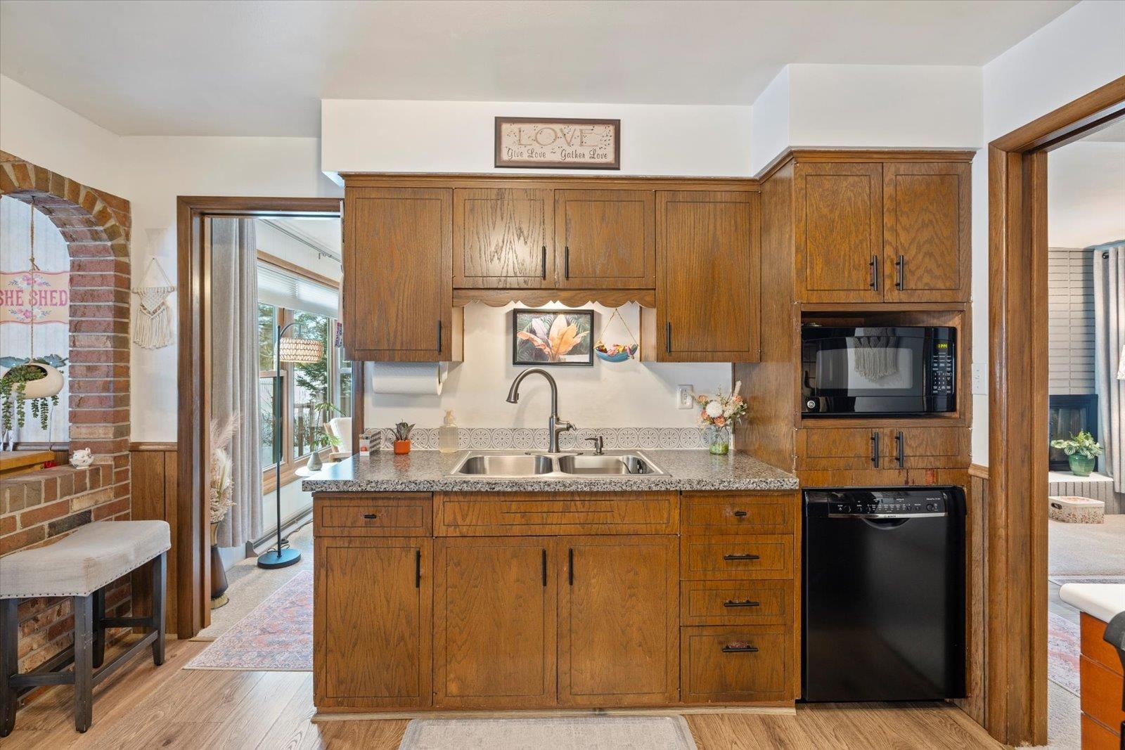 502 North Inner Drive Hibbing, MN 55746 - Photo 19 of 57 Kitchen with black appliances, wood finish cabinets, light wood-style floors, a wainscoted wall, and light countertops